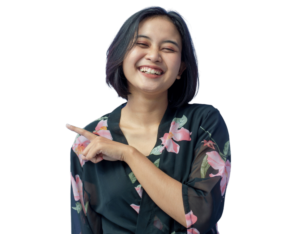 A young woman with short dark hair, wearing a black floral top, smiling and pointing to her left—ready to represent your trusted social media marketing agency with energy and style.